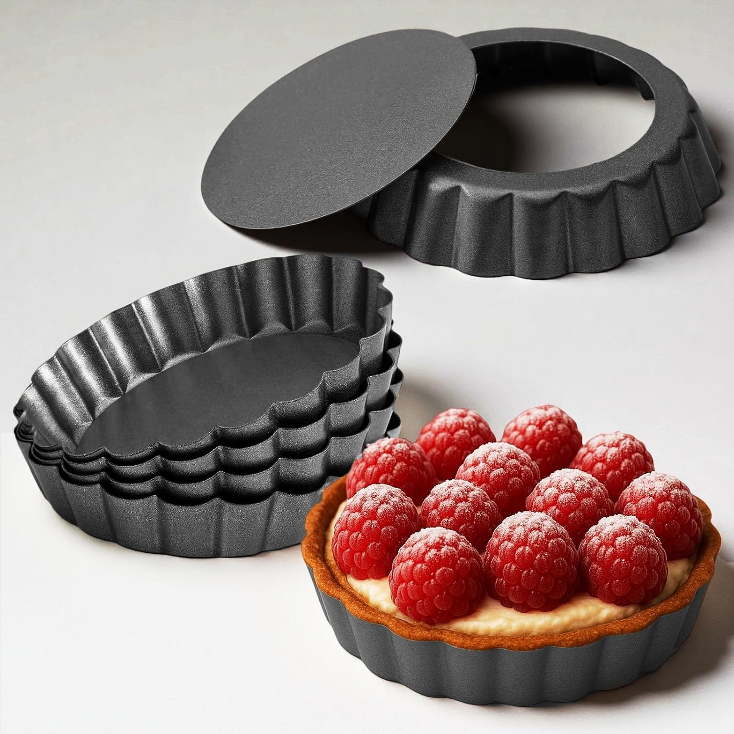 Yamteck 4IN tart pans set displayed on a wooden countertop with a fresh lemon tart partially removed
